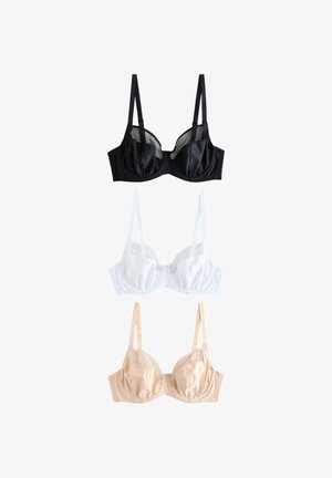 Femme aux cheveux blonds mi-longs portant un soutien-gorge couleur chair, posant avec un bras levé et regardant légèrement vers le haut.