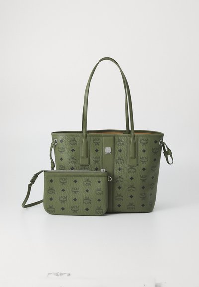 Sac fourre-tout en cuir vert avec motifs embossés, double poignée et petite pochette amovible à fermeture éclair. Intérieur doublé sans quincaillerie visible.