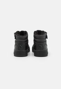 Czarne wysokie buty z cholewką z teksturowanego tworzywa sztucznego, miękką podszewką z polaru i żebrowaną gumową podeszwą. Zawiera pętlę ułatwiającą zakładanie.