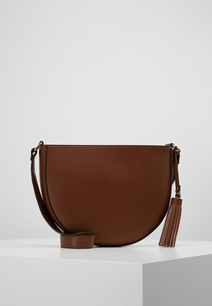 Braune, halbmondförmige Lederschultertasche mit langem Riemen und passender Quaste, die an der Seite hängt.
