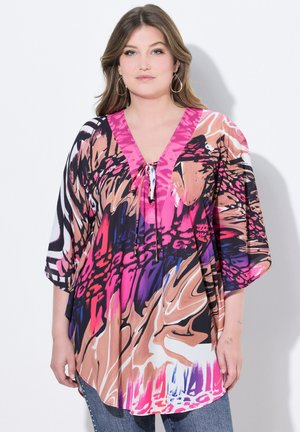 Mehrfarbiger Poncho-Oberteil mit V-Ausschnitt, das kräftige abstrakte Muster in Pink, Schwarz und Braun aufweist, sowie eine Kordelzug-Dekoration an der Vorderseite.
