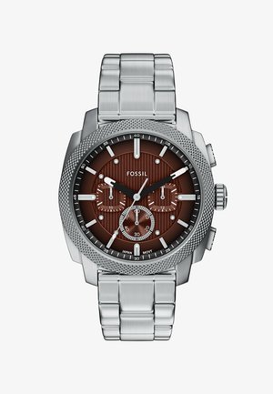 Sølv rustfrit stål ur med en mørkebrun tekstureret urskive, tre underskiver og hvide timemarkeringer. Har en skridsikker bezel og metalarmbånd.