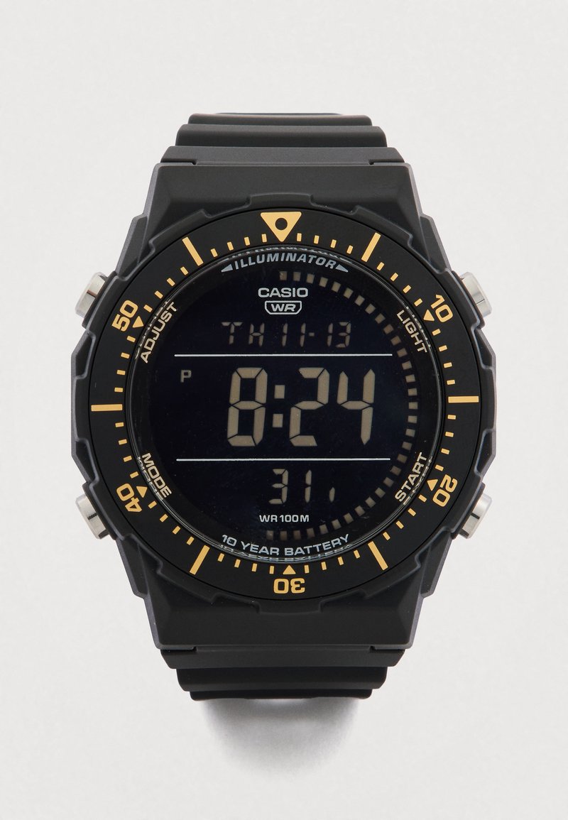 Cyfrowy zegarek z czarnym paskiem z gumy i czarną, teksturowaną kopertą. Posiada duży wyświetlacz LCD z białymi cyframi i pomarańczowymi akcentami. Wodoodporny.