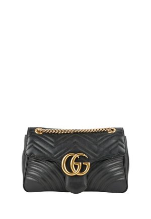 Bolso de cuero negro con costuras en chevron, cierre con logo doble G dorado y correa de cadena dorada.