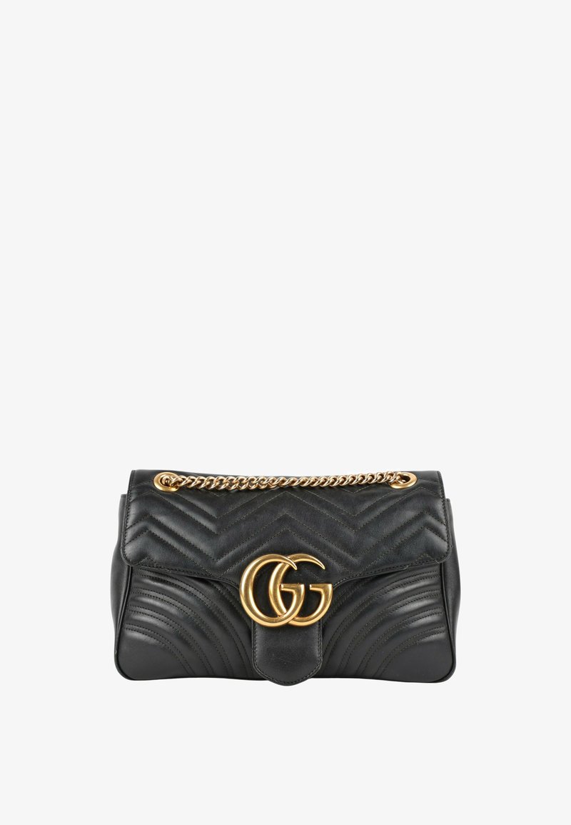 Sac à main en cuir noir avec surpiqûres chevron, fermoir logo double G doré et bandoulière chaîne dorée.