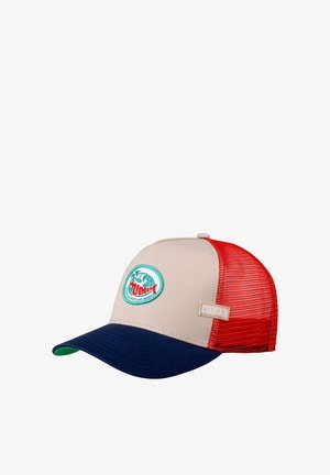 Beige trucker cap with red mesh sides and a navy brim. Features a circular embroidered patch depicting a wave and palm trees. Brand label visible.