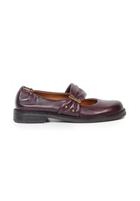 Chaussure plate en cuir bordeaux foncé pour femme avec petit talon et bride décorative ornée d'une boucle en laiton et de rivets, vue de côté.