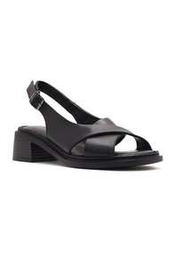 Sandalia de cuero negro con punta abierta, talón descubierto, tacón bajo y correa ajustable con hebilla.