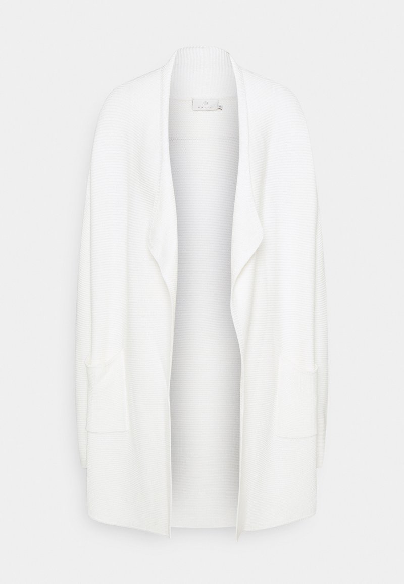 Vit, överstor kofta med öppen framsida, ribbad textur och två sidofickor. Enkelt design utan knappar eller dekorationer.