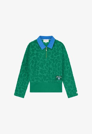Groene trui met lange mouwen, donker luipaardprint, felblauwe kraag, gouden rits en een klein logoplaatje aan de onderkant aan de linkerkant.