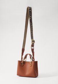 Brązowa skórzana torebka z złotymi akcesoriami i regulowanym beżowym materiałowym paskiem na ramię z czarnym logo "Emporio Armani".