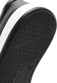 Semelle de chaussure noire avec un motif texturé de carrés. Présente une bande blanche le long du bord supérieur. Fabriquée en caoutchouc pour l'adhérence et la durabilité.