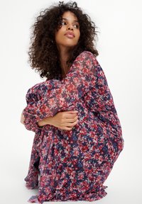 Maxikleid mit floralen Mustern aus transparenter Stoff in Rot und Marineblau. Lockere Passform, lange Ärmel mit elastischen Bündchen und gerafftem Taillendetail.