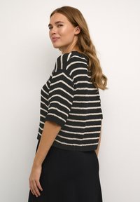 Maglione corto a maniche corte a righe bianche e nere con vestibilità ampia, scollo rotondo e orlo a coste; progettato per un look rilassato.