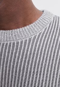 Pull en tricot à rayures grises avec un col rond côtelé, présentant des lignes verticales contrastantes en gris foncé et gris clair, et une texture douce.