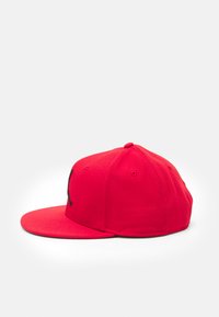 Căciulă roșie tip snapback cu vizor plat, având un logo brodat negru pe față. Fabricată dintr-un material textil cu un design structurat.