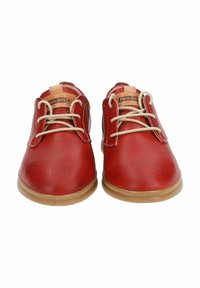 Scarpe in pelle rossa con una texture liscia, dotate di lacci beige e suola in gomma color nocciola. Etichetta del marchio visibile nella parte superiore.