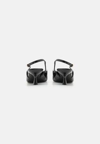 Svarta lackläder klacksandaler med en smal ankelrem, rund tå och en distinkt utfläkt klackdesign. Slät, glänsande yta.
