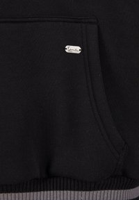 Black sweatshirt with a front pocket, textured fabric, and a silver logo tag. The hem has a contrasting ribbed gray accent.