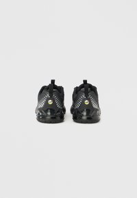 Ζευγάρι μαύρα αθλητικά παπούτσια με υφασμένο επάνω μέρος και ορατή εξάρτηση Air Max, παρουσιασμένα από πίσω σε απλό λευκό φόντο.