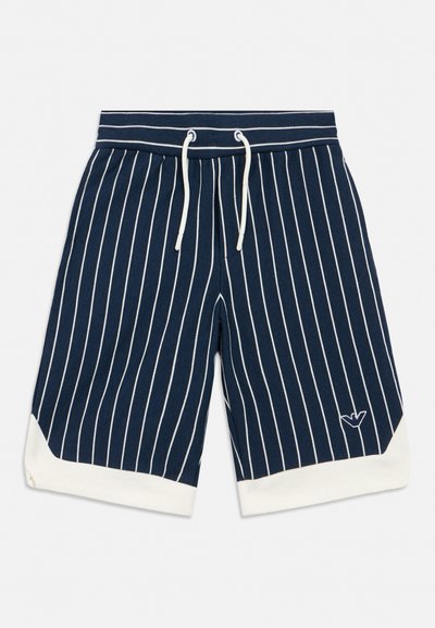 Pantalones cortos azul marino con rayas verticales blancas, cordón blanco, puños blancos y pequeño logo bordado cerca del dobladillo en una pierna.