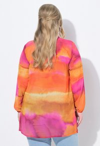 Camicia a maniche lunghe, di taglio morbido, in vibranti motivi tie-dye arancioni, rosa e gialli. Tessuto leggero con una finitura liscia.