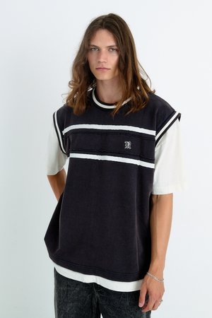 Camiseta de manga corta en blanco y negro, de ajuste relajado, que presenta rayas horizontales y un pequeño logo en el pecho.