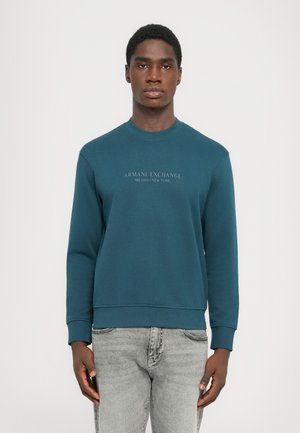 Tyrkisk bomullssweatshirt med rund hals, ribbede mansjetter og hem. Har fronttekst "ARMANI EXCHANGE MILANO/NEW YORK" i kontrastfarge.