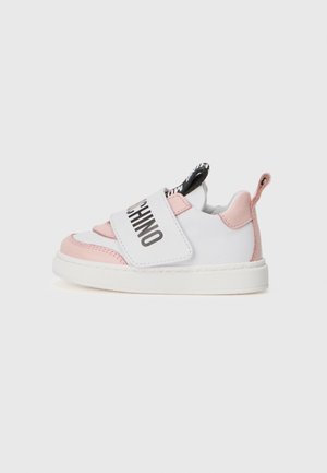 Baskets pour enfants blanches et roses avec une sangle Velcro, présentant un texte de logo noir et une semelle texturée. Bout arrondi et détail de talon contrastant.