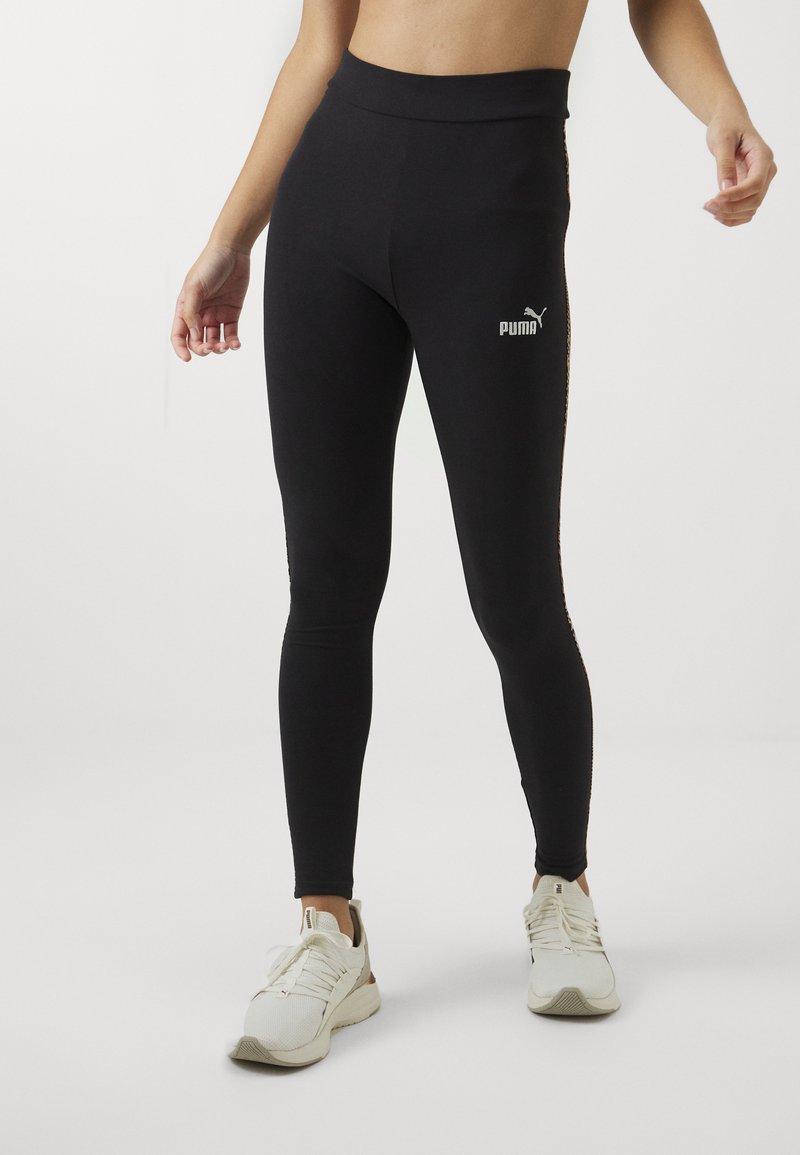 Leggings de entrenamiento negros, hechos de una tela elástica, con una cintura alta y un pequeño logo blanco de Puma en la parte delantera y un acento en el lateral.
