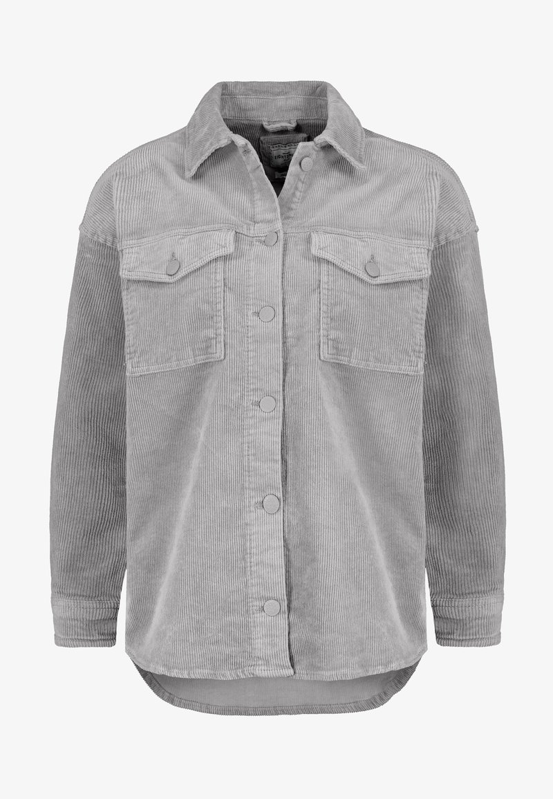 Giacca camicia in corduroy grigia con chiusura a bottone, due tasche sul petto e un orlo posteriore leggermente più lungo. Presenta una texture a coste e colletto rotondo.