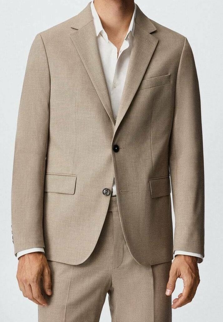 Completo marrone chiaro con una finitura testurizzata, caratterizzato da un giubbotto monopetto, revers a notchy, due tasche frontali e una camicia bianca sotto.