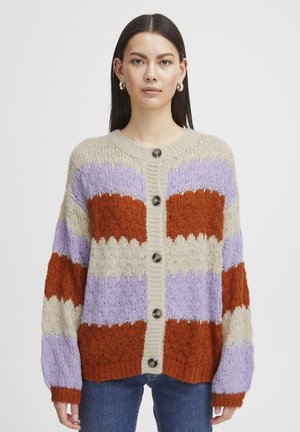 Cardigan en tricot présentant des rayures en zigzag orange, lavande et crème, avec un col rond, une fermeture à boutons et des poignets et un ourlet côtelés.