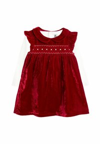 Rotes Samtkleid mit rundem Kragen, Rüschensleeves, gerafftem Oberteil mit Sternenmotiven und schwingendem Rock. Weiße Langarmbluse darunter.