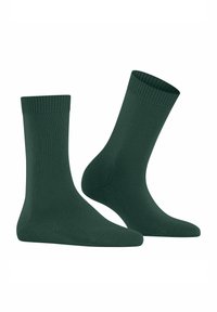 Un paio di calze a coste di colore verde scuro, mostrate affiancate su uno sfondo bianco.