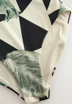 Bikiniunterteil mit einem schwarz-weißen geometrischen Muster und grünen Blattmotiven. Hergestellt aus glattem, dehnbarem Stoff mit sauberen Kanten.