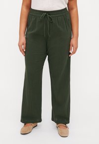 Pantalones anchos de pierna amplia en verde oscuro, ligeros, con cinturilla elástica y detalle de cordón. Tejido texturizado con un ajuste relajado.