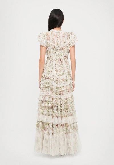 Witte bloemenmaxi-jurk met gelaagde ruches, korte pofmouwen en een gemêleerde bodice met een zigzagpatroon. Achteraanzicht weergegeven.