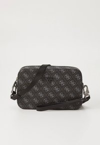 Czarna torebka typu crossbody Guess z szarym wzorem monogramu, prostokątnym kształtem, odpinanym paskiem i trójkątną plakietką z logo na środku.