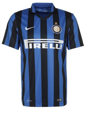 Mand i sort og blåstribet Inter Milan fodboldtrøje, sorte shorts og hvide sneakers går fremad mod en ensfarvet baggrund.