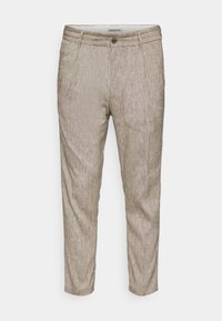 Lichtbeige taps toelopende broek van gestructureerde stof, met een enkele knoopsluiting en twee zijzakken.