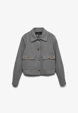 Veste grise courte en matériau doux, dotée d'un col évasé, de quatre poches frontales et de boutons marron. Texture lisse et design minimal.