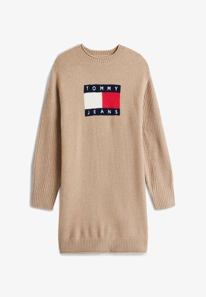 Beige long-sleeve knit sweater dress with ribbed sleeves and hem, featuring a Tommy Jeans logo patch in red, white, and navy blue.