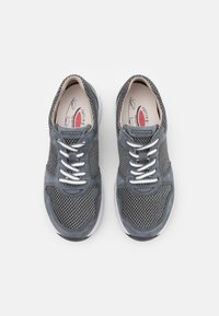 Graue Netzsneaker mit Wildlederakzenten, flachen weißen Schnürsenkeln und einer gepolsterten Innensohle. Abgerundete Zehenpartie und eine feste weiße Gummisohle.