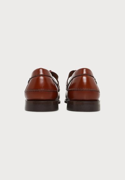 Paire de chaussures habillées en cuir marron poli, vues de dos sur fond blanc.