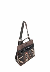 Bolso marrón y negro con cierre de cremallera, que presenta un patrón abstracto. El material es mixto, con una sección superior de cuero suave y una tela con estampado.