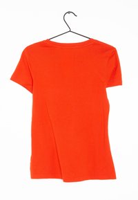 Camiseta de manga corta y cuello redondo en tela de color naranja brillante, exhibida en una percha. Textura suave sin patrones o acentos visibles.