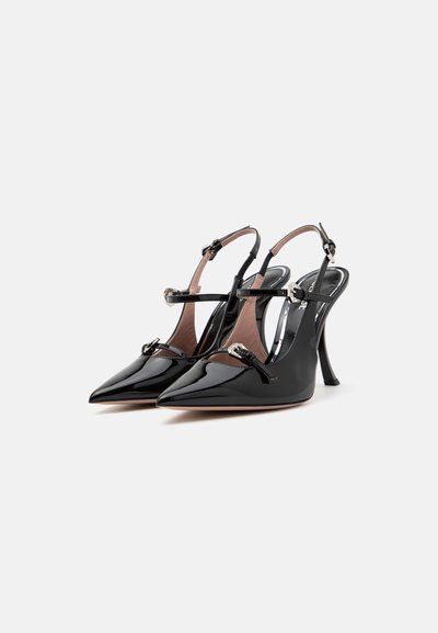 Tacones slingback de charol negro con punteras puntiagudas, que cuentan con delgadas correas en el tobillo y acentos de hardware metálico. Acabado suave y brillante.