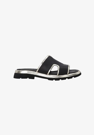 Zwarte leren slingback-sandaal met een metallic zilveren accent langs de zool en een gedurfde uitsnijding. Geribbeld zwart rubberen loopzool.
