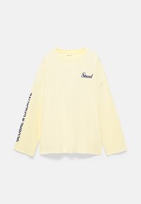 Cream long-sleeve shirt with "Stwd" on the chest and "GLOBAL & CREATIVE" printed along the right sleeve in dark blue letters.